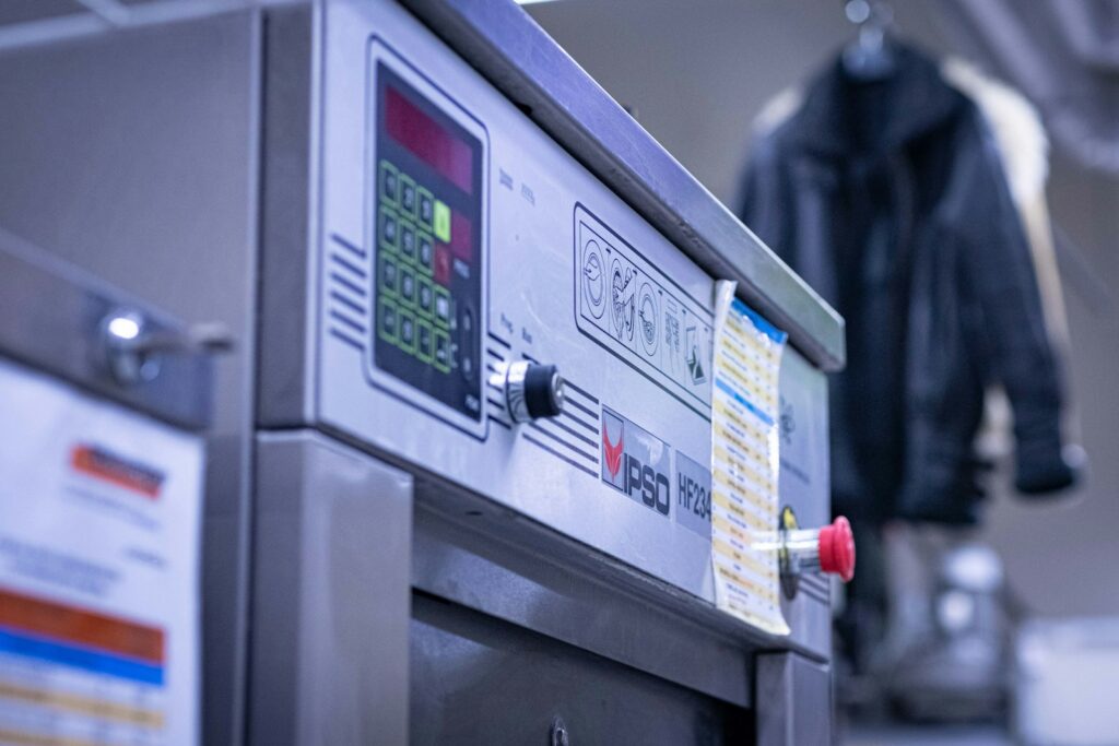 a close up of a machine with a jacket in the background